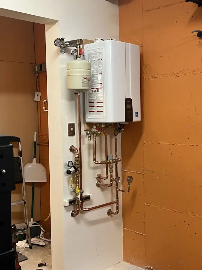 Plumbing technician inspecting water heater connections in Leonardtown